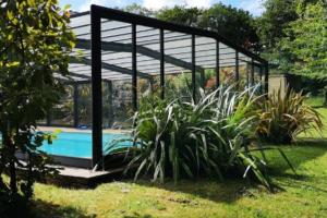 a pavilion with a pool in a garden at Chalet des Fées - Piscine in Crozon