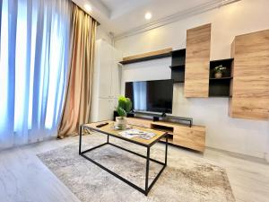 a living room with a table and a television at Double Studio A305 StayInn by Cosmopolis in Ştefăneştii de Jos