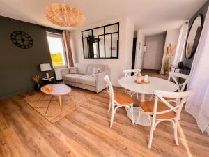 a living room with a table and chairs and a couch at Au Roupillon du Canal in Redon