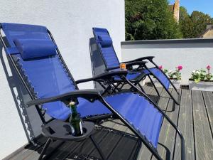 two blue chairs on a deck with a bottle of champagne at Chambres Senonches centre-ville in Senonches