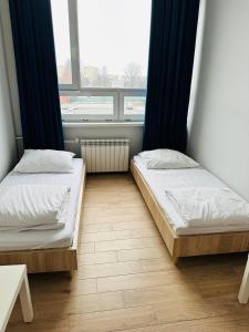 two beds in a room with a window at StarBal in Radom
