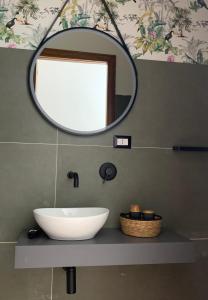 La salle de bains est pourvue d'un lavabo blanc et d'un miroir. dans l'établissement Casa Ammare, à San Leone