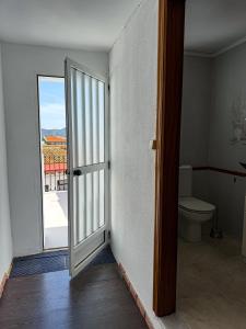 an open door to a bathroom with a toilet at Casa Naranja in Palma de Gandía