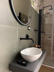 La salle de bains est pourvue d'un lavabo blanc et d'un miroir. dans l'établissement Casa Ammare, à San Leone