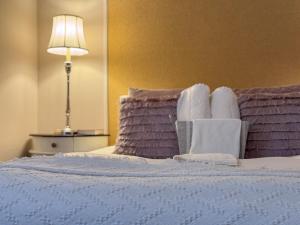 a bedroom with a bed with towels and a lamp at The Chatwal Boutique Hotel in Blackpool