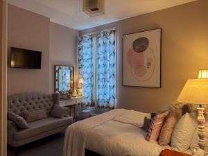 a bedroom with a bed and a couch and a chair at The Chatwal Boutique Hotel in Blackpool