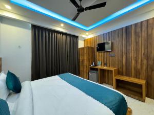 a hotel room with a bed and a television at Hotel Vaidik Ganga , Near Parmarth Niketan in Rishīkesh