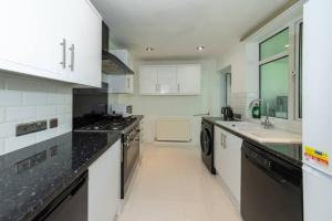 uma cozinha com bancadas e electrodomésticos a preto e branco em Enashipai House - Reading UK em Reading