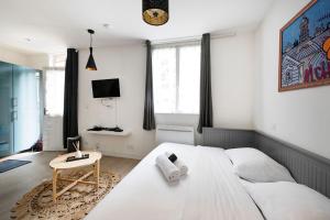 een slaapkamer met een groot wit bed en een tafel bij Chaleureux Studio 2 pers in Lyon