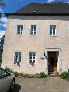 une maison avec une voiture garée devant elle dans l'établissement Zimmer auf dem Scheuerhof, à Wittlich