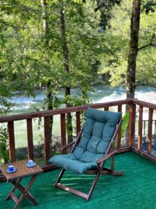 a chair with a blue cushion sitting on a deck at Zamane evleri in Çamlıhemşin