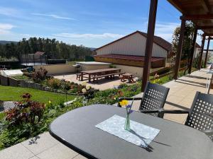 a table and chairs on a patio with a garden at Kastanienhof Selz in Spalt