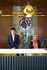 a man and a woman standing behind a counter at Hotel Tourmaline Peshawar in Peshawar