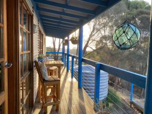a porch with a blue railing and a chandelier at Sheoak Lodge in Penneshaw