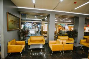 eine Lobby mit gelben Stühlen und Tischen in einem Geschäft in der Unterkunft Horon Hotel in Trabzon