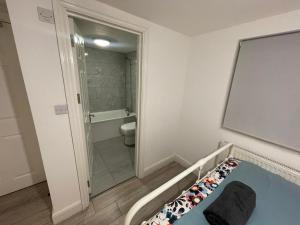 baño pequeño con cama y ducha en Sweet 7 bedroom Mansion London en Ilford