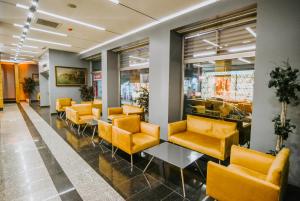 a waiting room with yellow chairs and tables at Horon Hotel in Trabzon