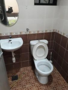 a bathroom with a white toilet and a sink at Jarzmin 3 Bedroom Apartment in Tanah Rata +3 photos
