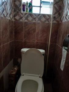 a small bathroom with a toilet with a window at Elite stay in Embu