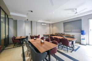 una sala da pranzo con tavoli, sedie e lavagna di FabHotel Prime Y Stay a Greater Noida