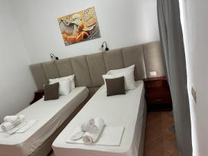 ein Hotelzimmer mit 2 Betten und Handtüchern darauf in der Unterkunft Oskar Hotel in Sarandë