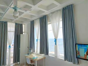 een kamer met een groot raam met uitzicht op de oceaan bij Seafront Studios and Apartments in Chios