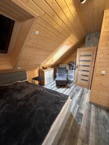 Gostyczyn的住宿－Blue Lake Villa，一间带一张床的卧室,位于带木制天花板的房间内