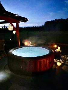bañera de hidromasaje en el patio por la noche en Blue Lake Villa, en Gostycyn