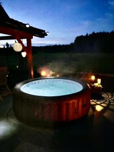 a hot tub sitting on a patio at night at Blue Lake Villa in Gostycyn