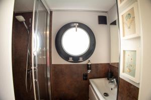 uma casa de banho com um chuveiro, um lavatório e um espelho. em The Homeboat Company Ponta Delgada-Açores em Ponta Delgada