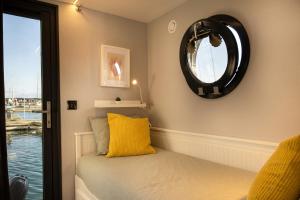 um quarto com uma cama com um espelho e uma janela em The Homeboat Company Ponta Delgada-Açores em Ponta Delgada