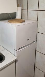 a white refrigerator in a kitchen with a cutting board on top at Casa Chato Casita San Roque in Alicante
