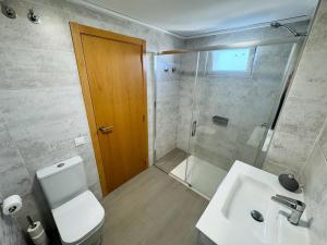 a bathroom with a toilet and a sink and a shower at Apartamento Playa Oliva in Oliva