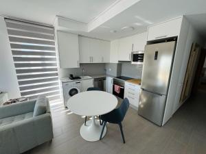 a kitchen with a white table and a refrigerator at Apartamento Playa Oliva in Oliva