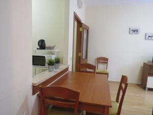 NEAT STUDIO in "FLORA" HOTEL في بوروفتس: غرفة طعام مع طاولة وكراسي خشبية