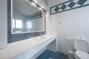 a white bathroom with a sink and a mirror at Paliouri Cottage by Luxlikehome in Paliouri +40 photos