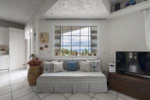a living room with a couch and a television at Paliouri Cottage by Luxlikehome in Paliouri