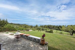 a garden with a bench and a table at Paliouri Cottage by Luxlikehome in Paliouri