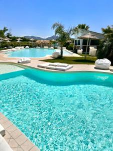 une grande piscine bleue avec des chaises longues. dans l'établissement La Siègià Resort spa, à Massa Marittima