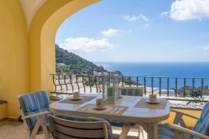 einen Tisch und Stühle auf einem Balkon mit Meerblick in der Unterkunft Residenza "il sogno di Geppino" al centro di Capri in Capri