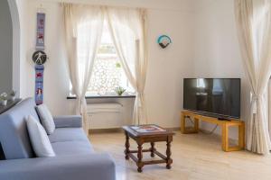 ein Wohnzimmer mit einem blauen Sofa und einem TV in der Unterkunft Residenza "il sogno di Geppino" al centro di Capri in Capri