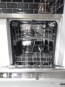 an open dishwasher with dishes inside of it at 4 Bedroom Edwardian House with Ensuite, Garden & Parking in Thornton Heath