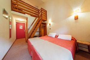 1 dormitorio con 1 cama grande y una escalera en Hôtel Club Le Risoux, en Bois-dʼAmont