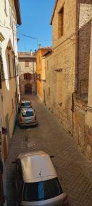 two cars parked on a street in an alley at B&B Antica Dimora in Pergola