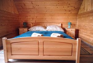 a bedroom with a bed in a log cabin at Górskie Chatki Krysi i Piotrka Błękitny in Stronie Śląskie