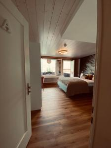 伊瑟特瓦德的住宿－Boutique Hotel Bellevue B&B am Brienzersee Iseltwald Interlaken，铺有木地板的客房内设有一间卧室和一张床。