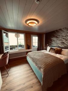 Un dormitorio con una cama grande y una ventana en Boutique Hotel Bellevue B&B am Brienzersee Iseltwald Interlaken en Iseltwald