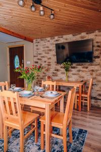 a dining room with a wooden table and chairs at Górskie Chatki Krysi i Piotrka Błękitny in Stronie Śląskie