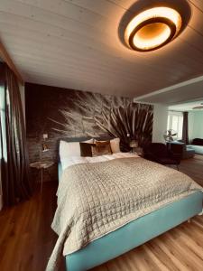 a bedroom with a large bed with a wall at Boutique Hotel Bellevue B&B am Brienzersee Iseltwald Interlaken in Iseltwald