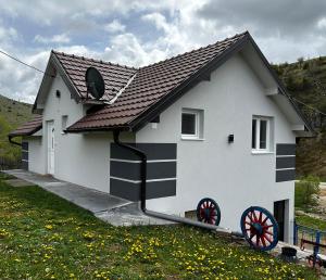 uma casa branca com um preto e branco em Odmorište Vrelo Vape em Sjenica